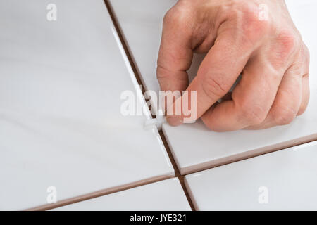 Close-up Of A Person's Hand Placing Spacers Between Ceramic Floor Tiles Stock Photo