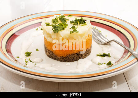 haggis, a very scottish dish, with mashed potato, turnips and parsley on a plate Stock Photo