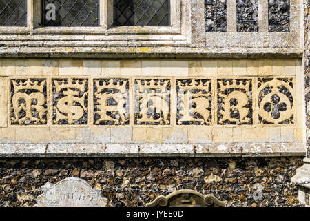 Flushwork in Lombardic script on the east end of Holy Trinity Church, Blythburgh, Suffolk, England Stock Photo