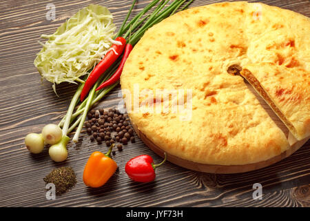 A colorful photo of traditional delicious beef osetinian pie. Traditional Ossetian feta cheese pie still life. Stock Photo