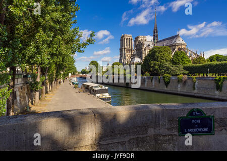 Notre Dame de Paris cathedral on Ile de La Cite with the Seine River in summer. Pont de l'Archeveche, Paris, France Stock Photo