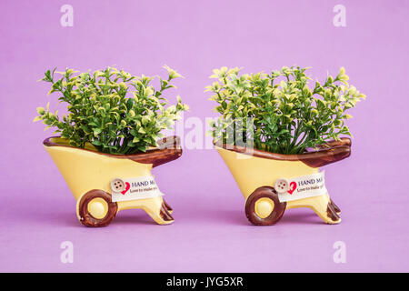 Small decorative artificial plants in yellow pots Stock Photo