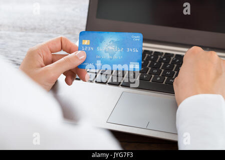 Close-up Of Businesswoman Hands Using Credit Card And Laptop At Desk Stock Photo