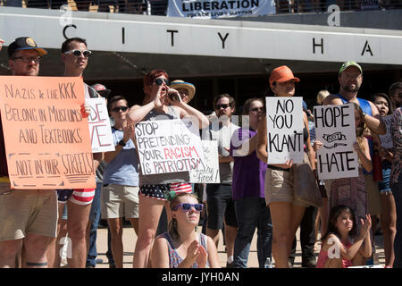 Activists and protesters converge on City Hall for a hot two-hour rally against racism and President Donald Trump's apparent insensitive comments about recent Charlottesville violence that left one dead. About 1,000 gathered in the August Texas heat. Stock Photo