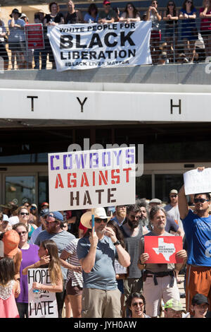 Activists and protesters converge on City Hall for a hot two-hour rally against racism and President Donald Trump's apparent insensitive comments about recent Charlottesville violence that left one dead. About 1,000 gathered in the August Texas heat. Stock Photo