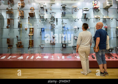 Berlin, Germany. 19th Aug, 2017. Visitors to the Musuem of Communication look at telephones from various eras in Berlin, Germany, 19 August 2017. Photo: Gregor Fischer/dpa/Alamy Live News Stock Photo