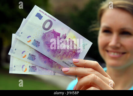 Castle Director Susanne Tiesler showing freshly printed 0 euro bills with the design of Castle Mildenstein in the Castle's courtyard in Leisnig, Germany, 17 August 2017. The souvenir money is printed on real euro paper and counts with all current security measures used on real money. Numerous collectors have expressed interest in the bills, which are limited to 10,000 exemplars and sell for 2 euros. Mildenstein Castle is the third location in Saxony's Castle Region, after Moritzburg Castle and Kriebstein Castle, offering these souvenirs. Photo: Hendrik Schmidt/dpa-Zentralbild/dpa Stock Photo