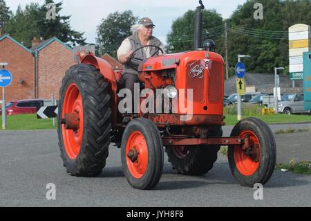 Kington, , UK. 20th Aug, 2017. The Herefordshire market town of Kington came to a standstill while a parade of vintage vehicles made their way to the Kington Vintage Club's 25th Annual Show. Mike George on his vintage Nuffield tractor makes his way in the parade. Credit: Andrew Compton/Alamy Live News Stock Photo