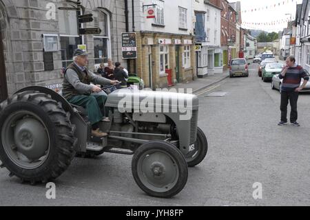 Kington, , UK. 20th Aug, 2017. The Herefordshire market town of Kington came to a standstill while a parade of vintage vehicles made their way to the Kington Vintage Club's 25th Annual Show. Barry Trumper drives his vintage tractor into the town's High Street with traffic bought to a standstill as they wait for the parade to finish. Credit: Andrew Compton/Alamy Live News Stock Photo