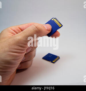 man hand holding a memory card on a white background. for information technology concept Stock Photo