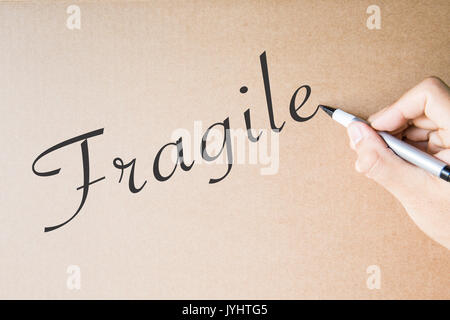hand writing fragile on brown paper background Stock Photo