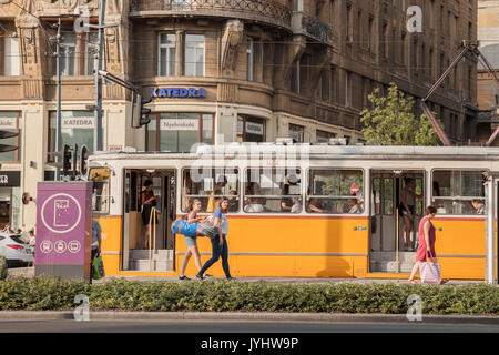 BUDAPEST, HUNGARY - AUGUST 11, 2017: Young and old people boarding a tram in the city center of Budapest, Hungarian capital city.  Picture of old and  Stock Photo