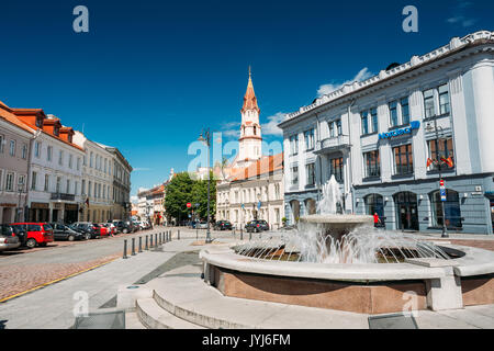 Vilnius, Lithuania - July 5, 2016: Town Hall Square Fountain In Rotuses Square In Old Town. St. Nicholas Church In Sunny Summer Day. Popular Touristic Stock Photo