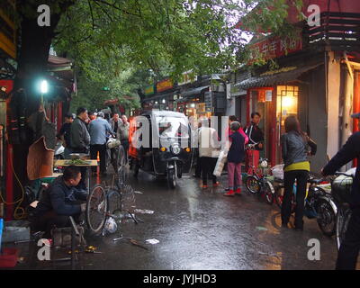 Beijing, China - 07 October, 2016: A food market in an old Beijing hutong in the rain Stock Photo