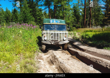 Heavy powerful truck-terrain vehicle with off-road wheels to overcome obstacles in difficult terrain. Russian military equipment in action. Stock Photo