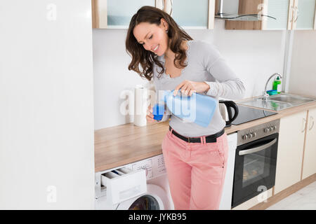 Young Happy Woman Pouring Liquid Detergent In The Bottle Cap Stock Photo