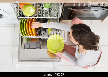 High Angle View Of Young Woman Doing Housework In Kitchen Stock Photo