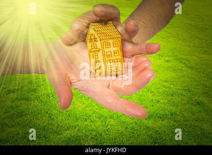 bright picture of woman holding wooden house Stock Photo