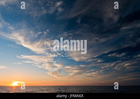 Beautiful sunset over the sea with cloudy sky Stock Photo
