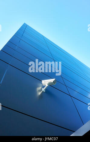 Closed circuit television (CCTV) camera on an office building wall. Stock Photo