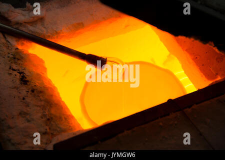 Handmade figure of melted glass, a glass blower working molten glass on a rod Stock Photo