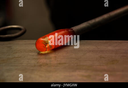 Handmade figure of melted glass, a glass blower working molten glass on a rod Stock Photo