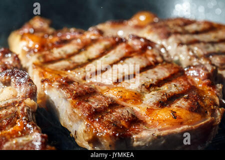 Raw Ribeye Steak with Herbs and Spices, frying on grill pan. Stock Photo