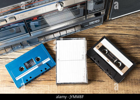 compact cassette tapes and cassette player ghettoblaster on wooden table Stock Photo