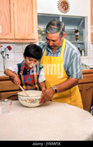 granddad mixing batter teaching cute small little boy role model preschooler pre-k adoring adorable generations chore helping help caretaker Myrleen Pearson Stock Photo