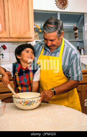 granddad mixing batter teaching cute small little boy role model preschooler pre-k adoring adorable generations chore helping help caretaker Myrleen Pearson Stock Photo