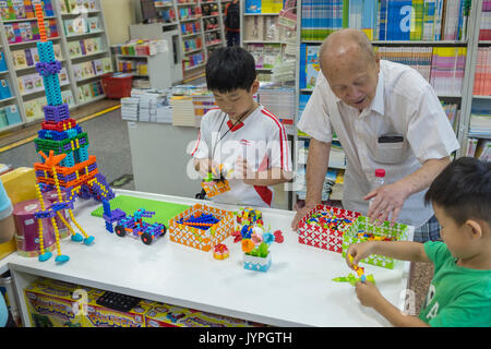 Children play Chinese-made plastic construction toys similar to LEGO in a bookstore in Beijing, China. 19-Aug-2017 Stock Photo