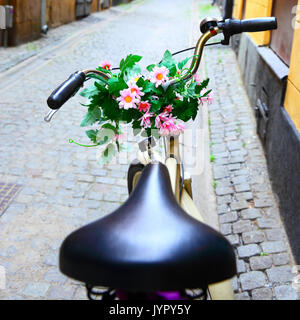 Bicycle with bunch of flowers on handle bar in Stockholm, Sweden. Shallow DOF! Stock Photo