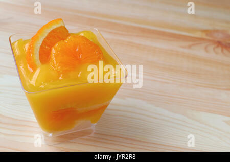 Vibrant Color Mandarin Orange Cake Topped with Fresh Orange in Glass Bowl Served on Wooden Table Stock Photo