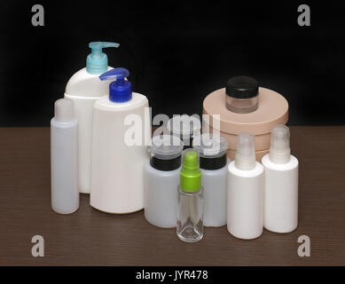 Closed empty toiletries containers on wooden shelf Stock Photo
