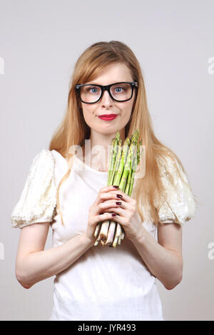 Young woman holding a bunch of asparagus in her hands Stock Photo