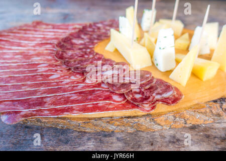 Cold meat plate on cutting board on wooden background Stock Photo