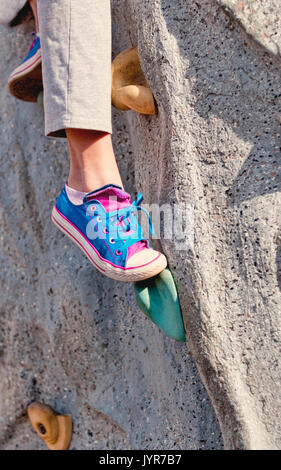 Closeup of tennis shoe on rock wall stretching to grab the next hold. Stock Photo