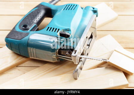Electric jigsaw closeup On wooden table work tools concept. Stock Photo