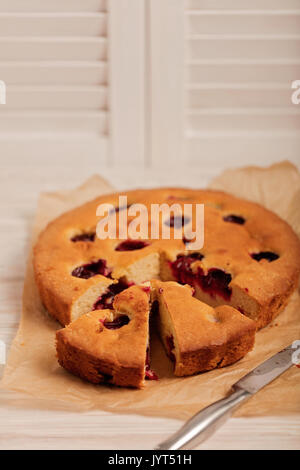 Home plum pie on baking paper. Selective focus. Stock Photo