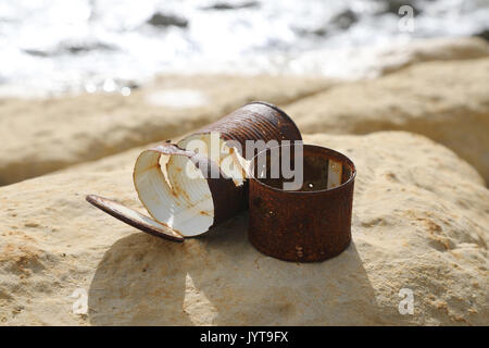 Old rusty cans left on the sea shore Stock Photo