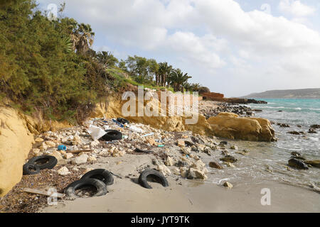 Litter and discarded old tires on the sea shore in Malta Stock Photo