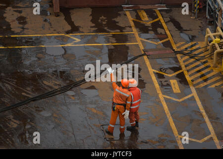 Two Saipem employees on the deck of the Saipem S7000 heavy lifting vessel. credit: LEE RAMSDEN / ALAMY Stock Photo
