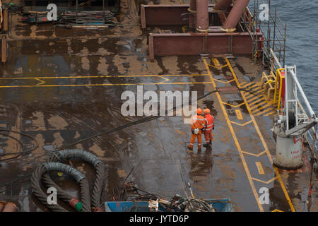 Two Saipem employees on the deck of the Saipem S7000 heavy lifting vessel. credit: LEE RAMSDEN / ALAMY Stock Photo