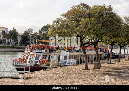 SEVILLE, SPAIN - MARCH 14, 2016:   City tour boat tied up to the bank on the River Guadalquivir Stock Photo