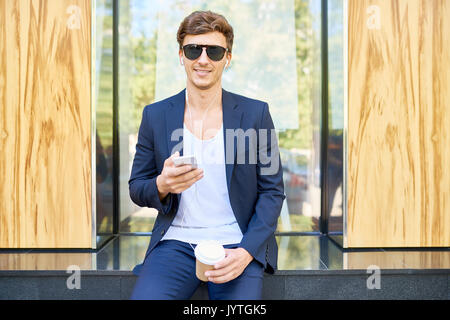 Elegant Young Man Posing with Smartphone Stock Photo