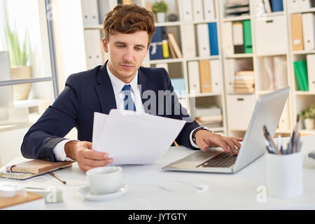 Modern Businessman Reading Documents in Office Stock Photo