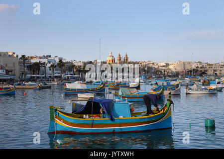 Traditional colorful fishing boats Luzzu moored at Marsaxlokk (Marsascala) Harbor, Malta Stock Photo