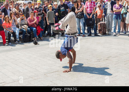 PARIS, FRANCE -  APRIL 25:B-boy doing some breakdance moves in front a street crowd, at Arch of Triumph on april 25, 2013 in Paris. Stock Photo