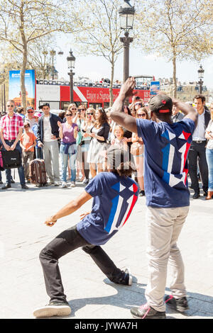PARIS, FRANCE -  APRIL 25:B-boy doing some breakdance moves in front a street crowd, at Arch of Triumph on april 25, 2013 in Paris. Its popular form o Stock Photo