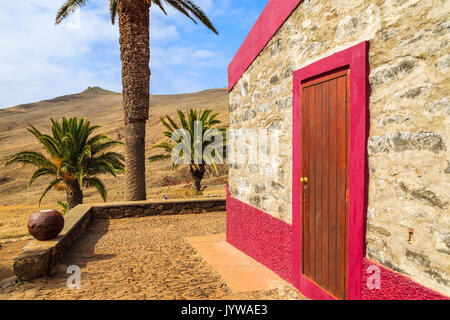 Old house in palm tree oasis in desert landscape on trekking trail at Punta de Sao Lourenco peninsula, Madeira island, Portugal Stock Photo